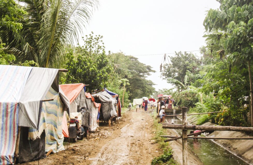 a dirt road with tents on the side