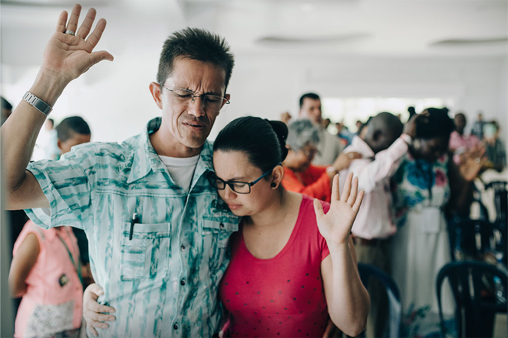 Couple praying in larger group